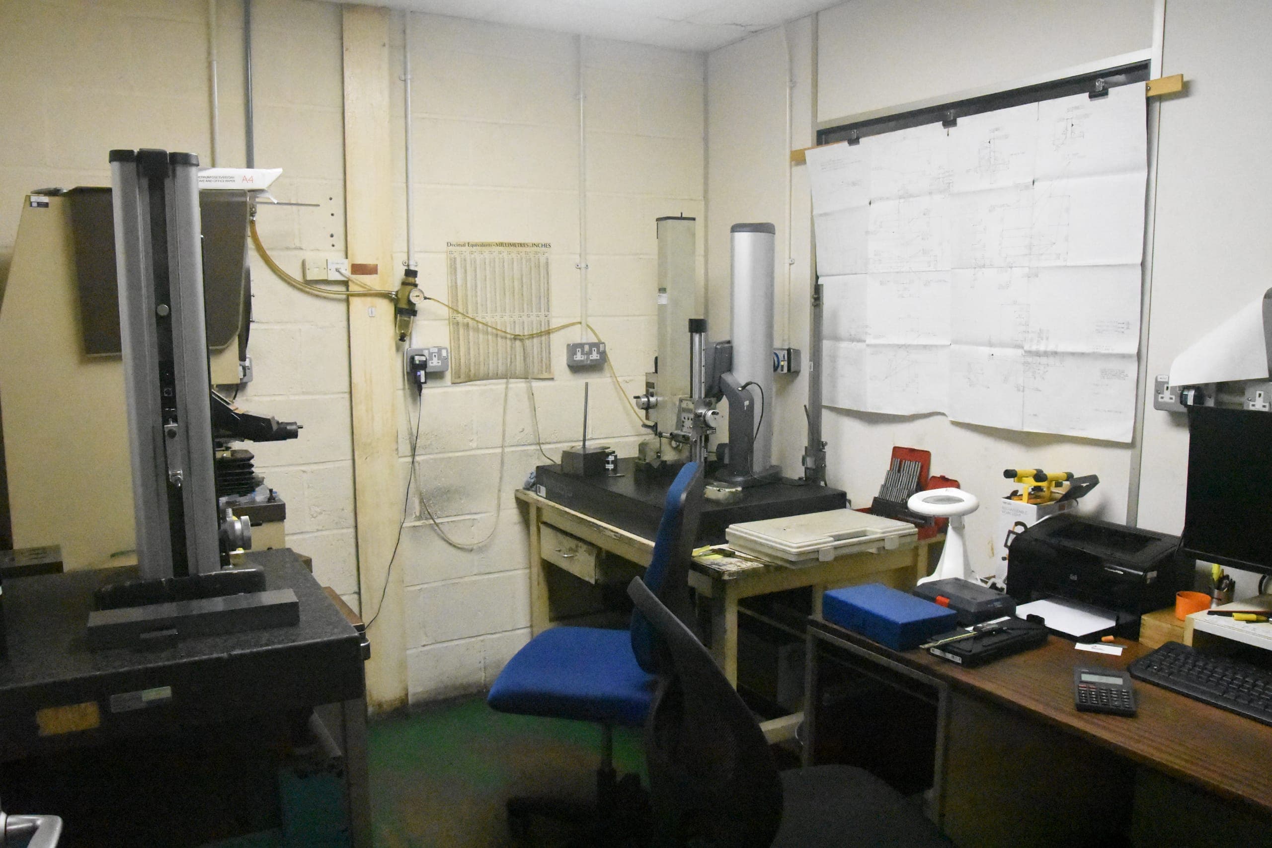 Engineer reviewing component measurements at a CMM inspection workstation